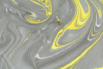 Abstract background. Ink marbling texture. Grey, yellow and white. Hand drawn marble illustration, ebru aqua paper and silk print. Traditional Turkish ebru technique. Painting on water. 
