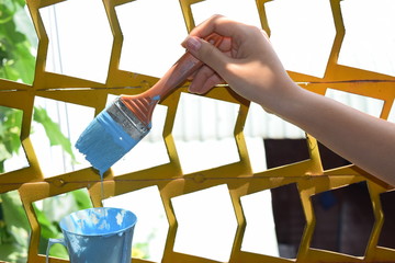 closeup young person painting the fence