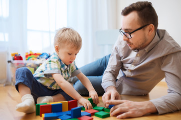 Obraz premium father and son playing with toy blocks at home