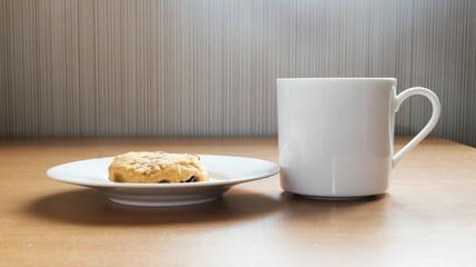 Coffee and cookies placed on a wooden table.