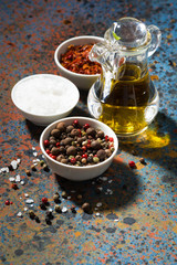 assortment of pepper, sea salt and olive oil on dark background