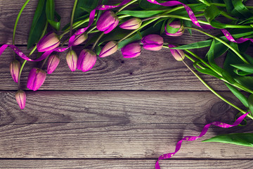 Bouquet of purple tulips with ribbon on a old wooden background