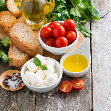 mozzarella and ingredients for the salad on a wooden background