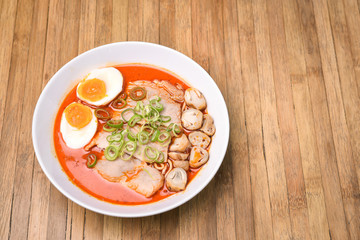 Spicy Tom Yum, Creamy Pork Ramen with egg and mushroom on wood b