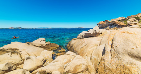 man kayaking by Sardinian rocky coastline