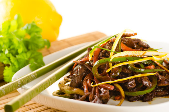 Beef, carrots and green bell pepper in asian citrus sauce with c