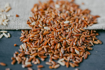 Red rice on black wooden background