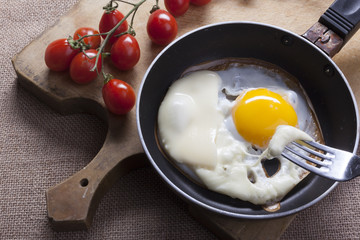 Fried eggs in a round pan wth cheese slices