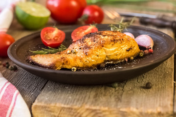 fresh raw salmon steaks with salt, peppers, lemon, tomatoes and dill on the rustic table
