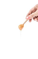 Honey dripping, honey dipper with hand on white background