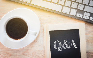 Concept Q&A message on wood boards. A keyboard and a glass coffee table.Vintage tone.