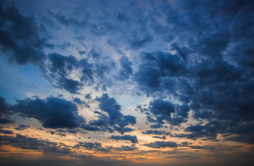 Naklejka na ściany i meble Big blue clouds on the sunset background.
