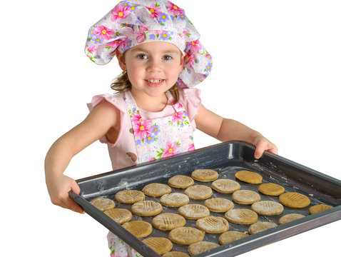 Little Girl Holding A Tray Of Cookies On A White Background