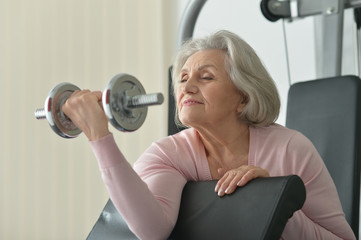 Elderly woman exercising in gym