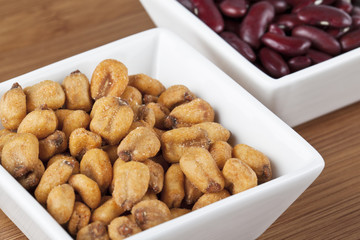 close-up image of roasted peanuts and kidney beans in background.
