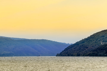 Orangy sky in sunset above river and hills