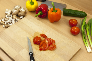 Knife laying next to a freshly sliced salad tomato