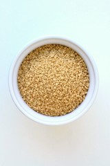 Wholegrain couscous in the bowl on the white background