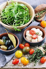 Antipasto concept  including mozzarella cheese,olives and ham with tomatoes and arugula.Selective focus.