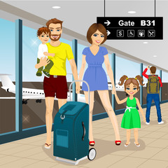 Happy family with suitcase standiing in airport 