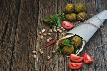 Falafel wrapeed in pita on wooden table