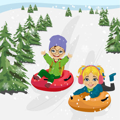 little boy and girl sliding down hill on tubes