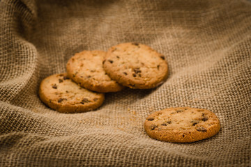Christmas cookies on a wooden table covered in jute. Horizontal concept image for holiday background.