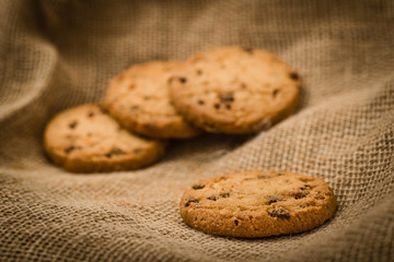 Christmas cookies on a wooden table covered in jute. Horizontal concept image for holiday background.