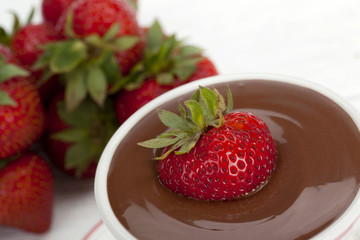 strawberry dipped in melted chocolate in a bowl