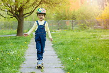 Fototapeta premium Adorable preschool child skateboarding on the street