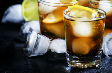 Alcoholic cocktail rum cola with ice, lime, lemon, cola and whit