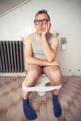 Man sitting on toilet bowl