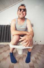 Man sitting on a toilet bowl