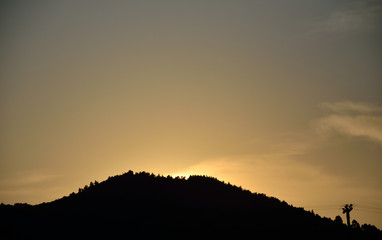 Silhouette of the hill where the sun goes down in evening