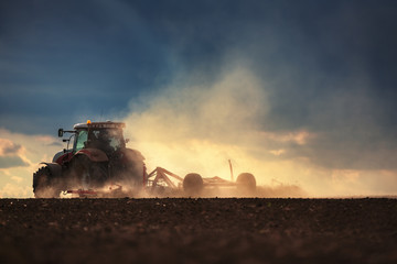 Farmer in tractor preparing land with seedbed cultivator