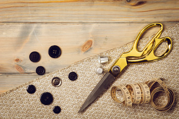 Background with sewing and knitting tools and accesories. Set for needlework placed on flax fabric. Image taken from above, top view. A lot of copyspace.