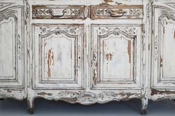 Close-up of keyhole ancient white commode bureau furniture with paint peeled off 