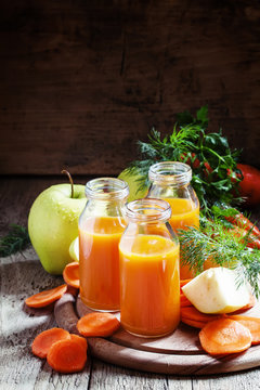 Apple-carrot orange smoothie small glass bottles, vintage wooden