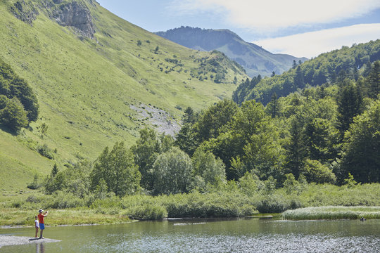 Father and daughter enjoying lake, Valle de Aran, Spain