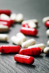 Painkillers pills in red and white capsules on dark background,