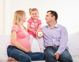 Young pregnant woman, with husband and little daughter 