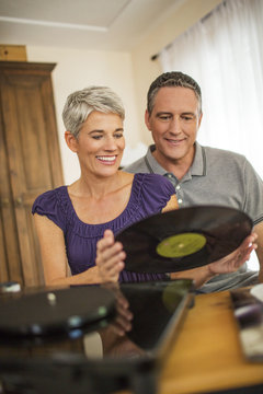 Romantic mature couple playing vinyl records