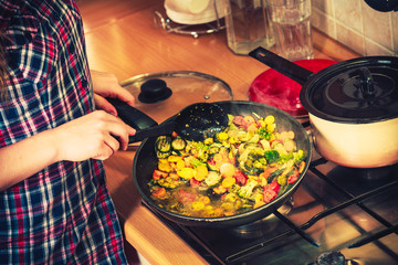 Human frying frozen vegetables. Stir fry.