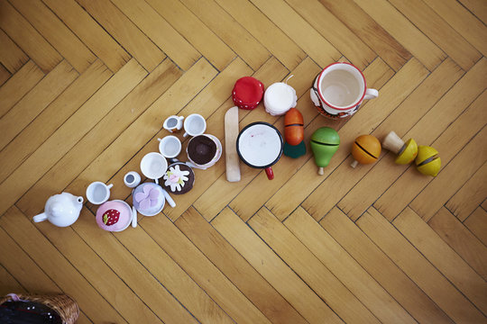 Overhead view of cupcakes, toys and cups on parquet floor