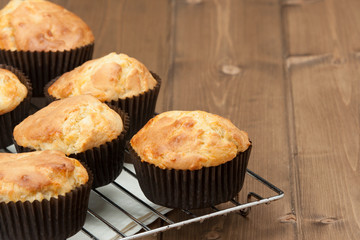 Homemade Cheddar Muffins In Paper Cases. Wooden Table.
