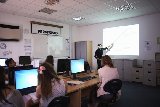 Computer teacher teaching in classroom