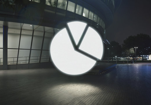 Glowing pie chart symbol in city at night