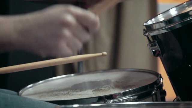 Musician playing drums at studio, close up, slow motion