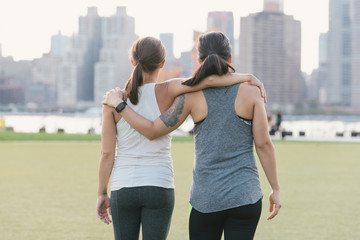 Two friends warming up to exercise together outdoors