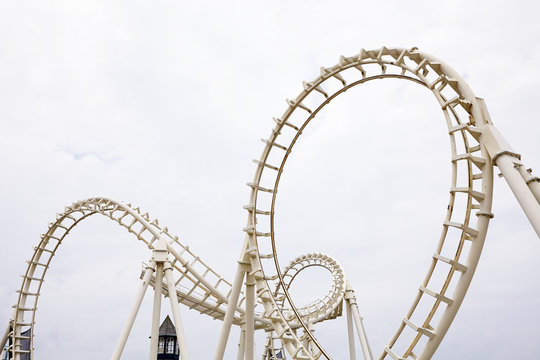View of amusement park rollercoaster against grey sky